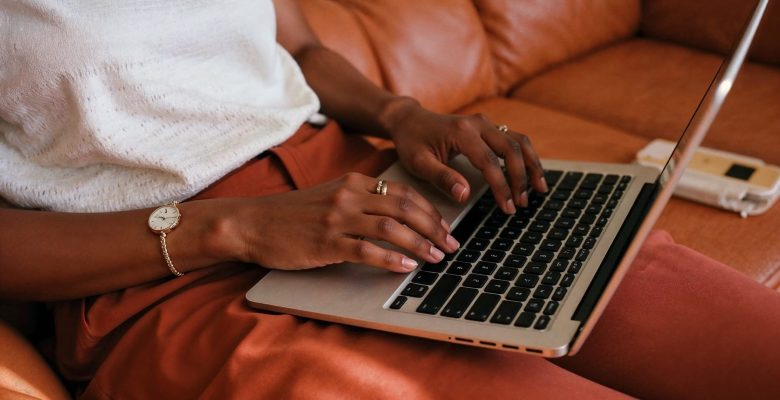 Woman working on a laptop wearing a white blouse